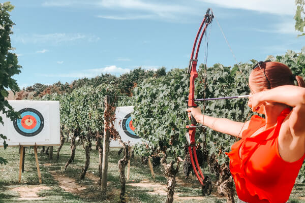 Archery Archer with bow and arrow taking aim at bullseye.