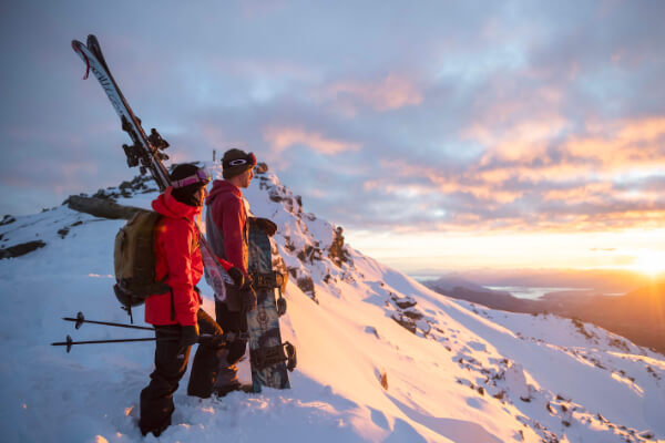Cardrona Couple of skiiers looking at the horizon at a beauiful sunset at the top of the mountain.