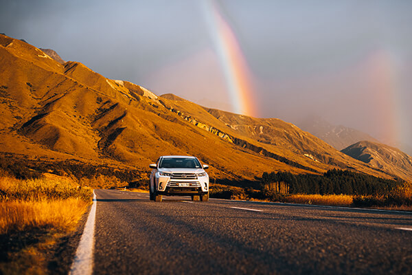 Omega's Luxury SUV with rainbow in the background.