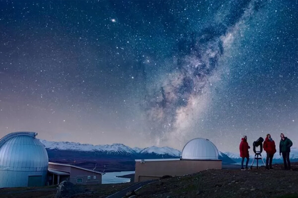 the Milky Way over the Mt John Observatory domes at night.