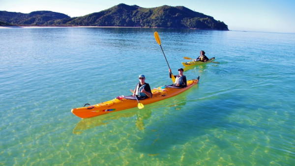 Tourists enjoying a guided sea kayaking tour at Abel Tasman National Park.