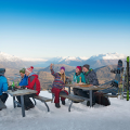 Tourists enjoying the view of Queenstown's snow covered mountains after skiing.