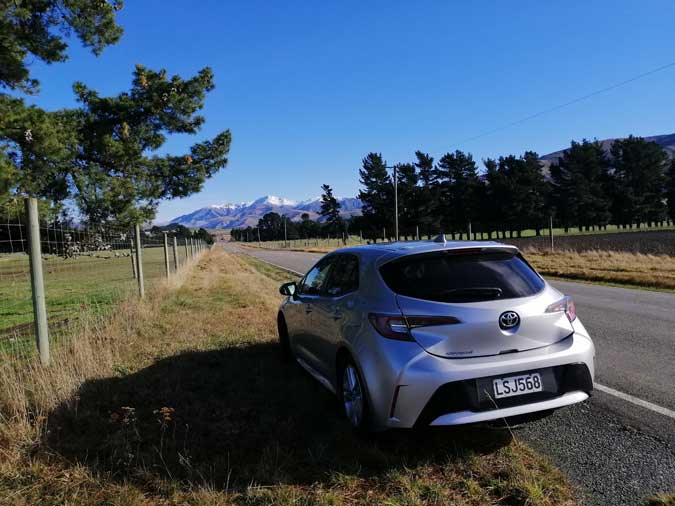 A car is parked admiring the view on the road to Mt Lyford.