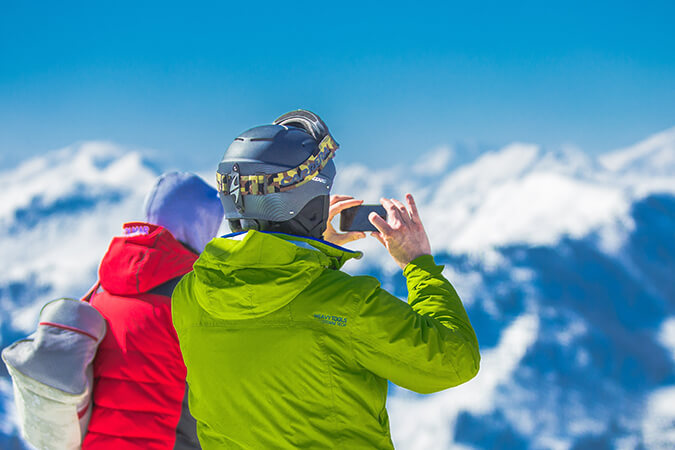 Tourists taking photos of New Zealand mountains covered with snow.